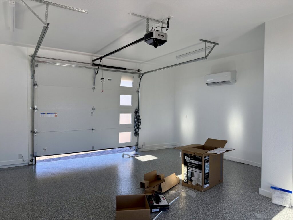 A mini-split indoor unit installed on the wall of a garage by Mi Amigo HVAC in Surprise, AZ
