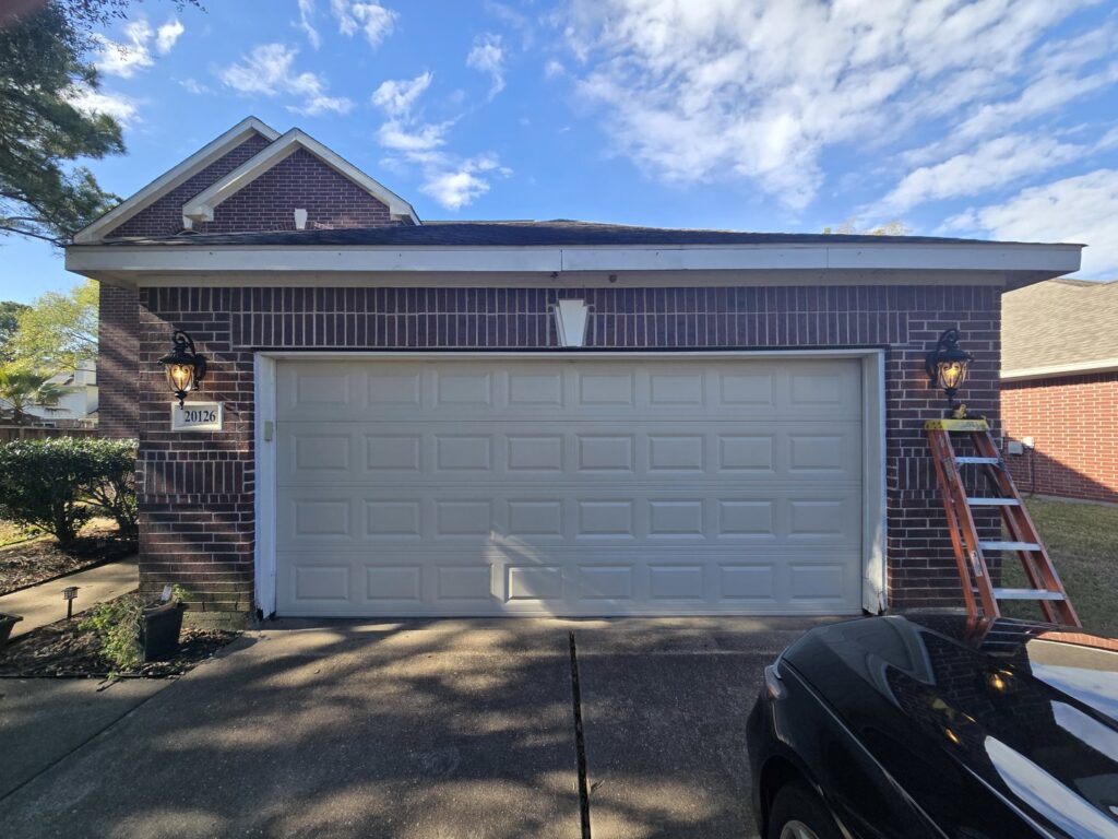 New outdoor wall lights installed on a garage exterior, with a ladder nearby, by Ponce Electric in Houston, TX