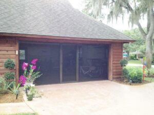 Three dark garage screen doors installed on a wooden garage by Access Garage Doors-Chattanooga, TN