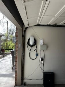 A garage featuring a Tesla electric vehicle charger and other electrical installations by Premier Power in Edmond, OK.