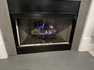 A gas fireplace with blue flames, indicating a heating system inspection by Komfort Air Service Experts in Charlotte, NC.