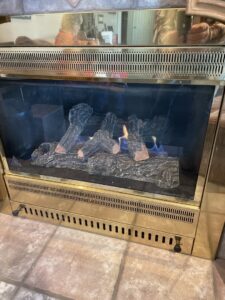 A newly installed gas fireplace with artificial logs and flames by The HVAC Doc in Rock Springs, WY