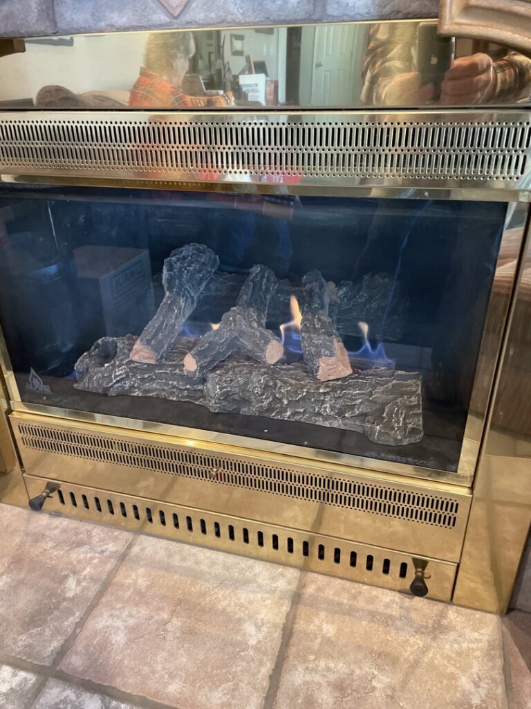 A newly installed gas fireplace with artificial logs and flames by The HVAC Doc in Rock Springs, WY