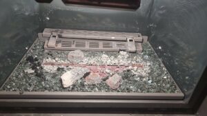 The interior of a gas fireplace showing decorative elements and debris, ready for cleaning by Top Dog Hearth Repair & Maintenance, LLC in Worcester, MA