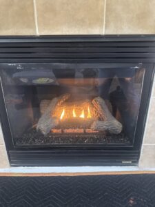 A cozy gas fireplace with burning logs, serviced by Nevada Heating Reno in Sparks, NV.