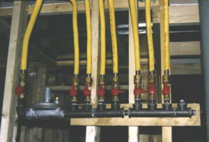 Newly installed yellow flexible gas lines and manifold for an HVAC system by Bowers Heating and Air Conditioning in Wichita, KS