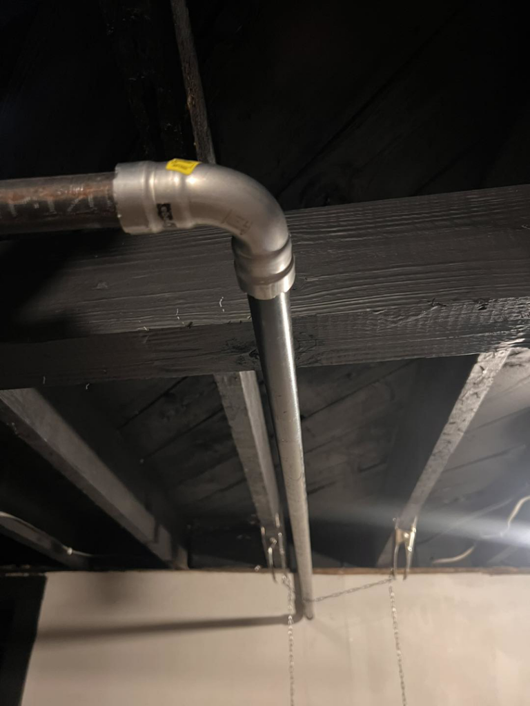Gas piping installed along a basement ceiling, showcasing professional work by Basurto's Heating & Cooling in Milwaukee, WI.