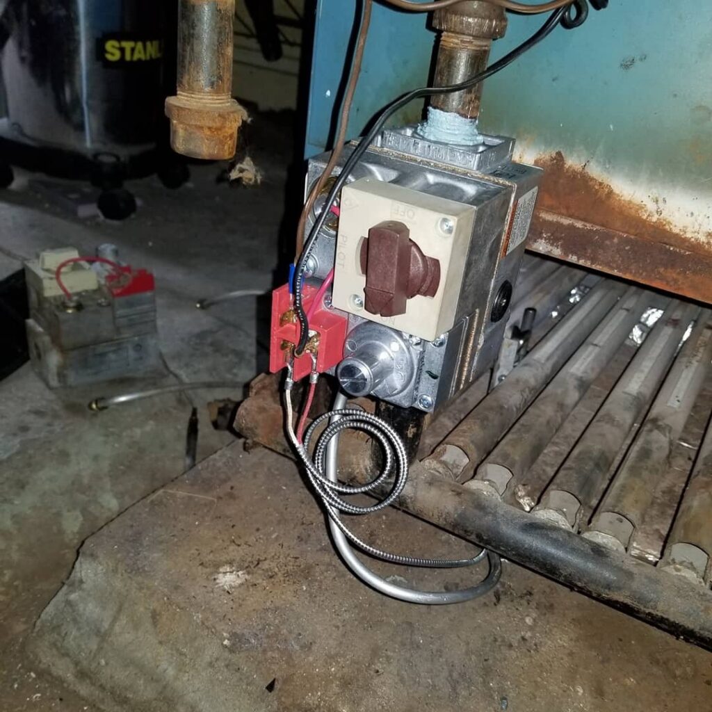 A close-up of a gas valve and piping on an HVAC boiler, serviced by Batista Heating & Cooling, LLC. in Charlotte, NC.
