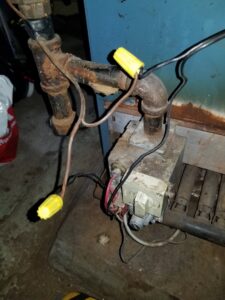 A close-up of gas valve wiring and components on an older boiler during service by Batista Heating & Cooling, LLC in Charlotte, NC.