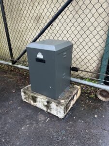 A gate operator motor installed next to a chain link fence by Gates Contractors in Plymouth, MN.