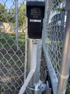 A gate safety sensor installed on a chain-link fence post by Brothers Gate Operators and Services LLC in Olathe, KS.