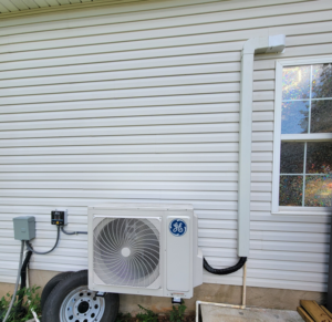 A GE brand outdoor mini-split HVAC unit installed on a house with vinyl siding by Smoky Mountain Ducts & Vents in New Market, TN.