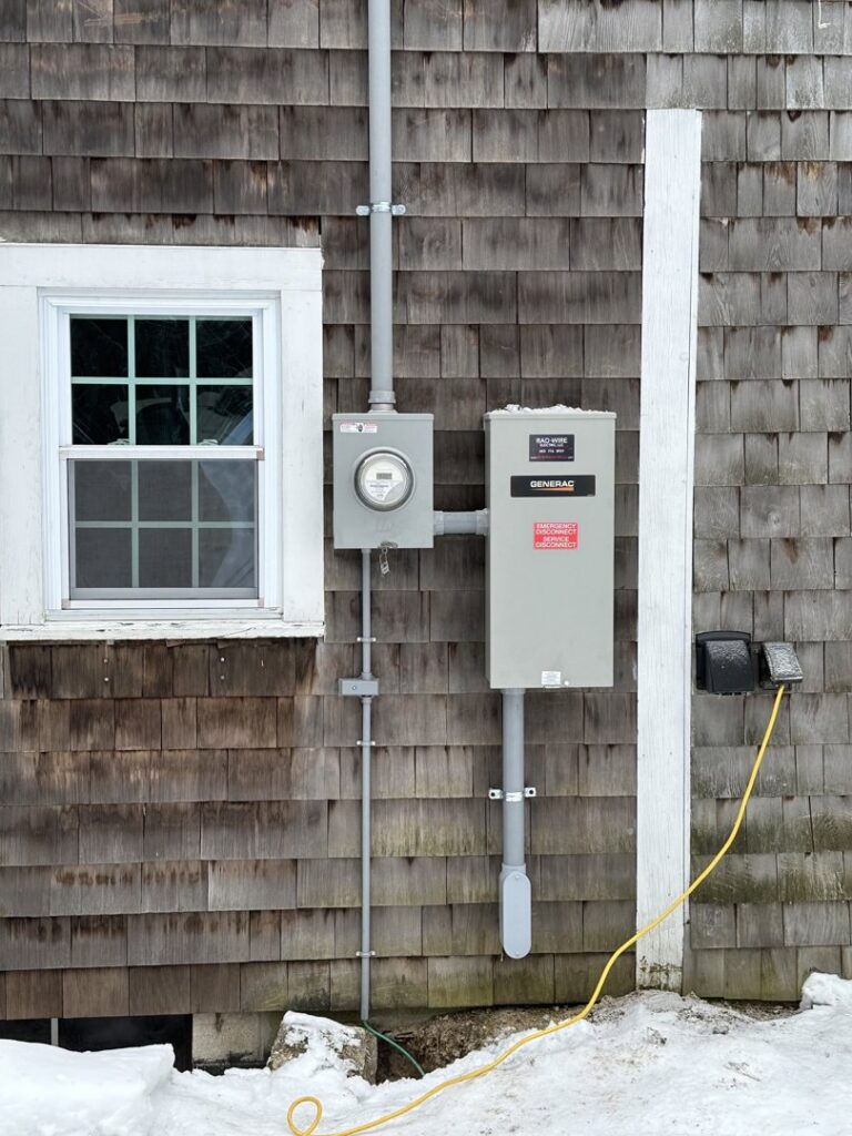 An exterior Generac generator and electrical meter installation on a home by RAD-WIRE ELECTRIC, LLC in Manchester, NH.