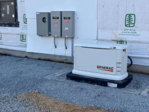 A Generac generator and exterior electrical panels installed on a building under construction by Moser Electric in Wisconsin Rapids, WI.