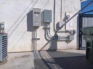 An outdoor Generac generator and electrical panel installation with conduits by Ride the Lightning Electrical Services in El Cajon, CA.