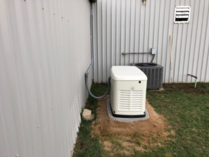 An outdoor Generac generator unit installed next to a building by Burton Controls in Oklahoma City, OK.