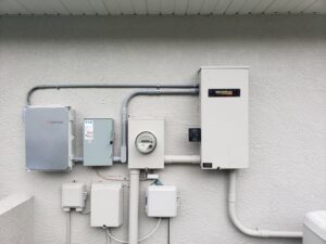 Generac generator and electrical service boxes installed on an exterior wall by Everyday Electric in Tampa, FL.