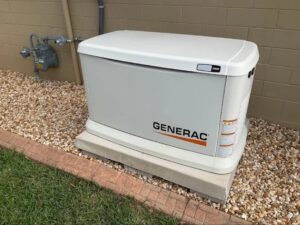 A Generac standby generator installed on a gravel bed next to a residential home by Generator Maintenance of Georgia in Atlanta, GA.