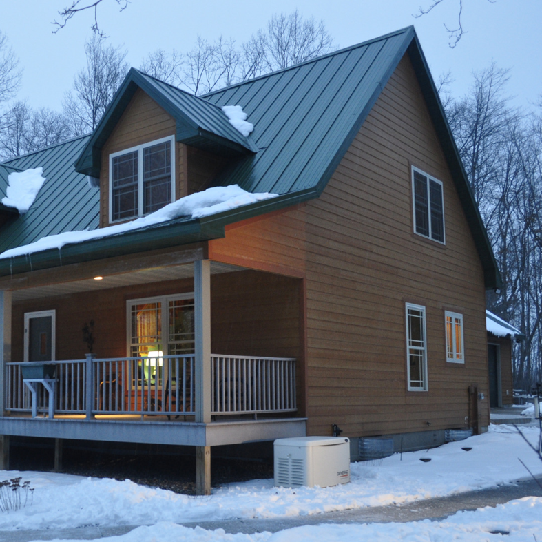 A Generac generator installed at a house in a snowy landscape by Cenla Generators in Alexandria, LA.