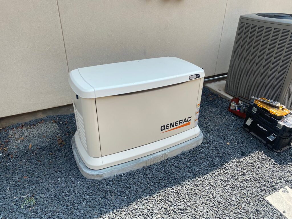 A Generac whole-home generator installed on a gravel bed next to an AC unit by Never Without Power Generators LLC in Huffman, TX.