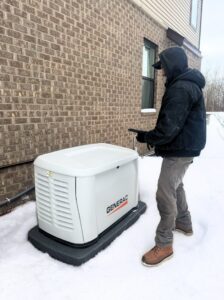 A Kelley Brothers LC technician testing a Generac standby generator during winter conditions in Livonia, MI.
