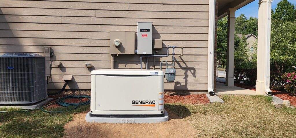 A Generac standby generator installation showing the electrical meter and automatic transfer switch on the house wall in Atlanta, GA.