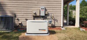 A Generac standby generator installation showing the electrical meter and automatic transfer switch on the house wall in Atlanta, GA.