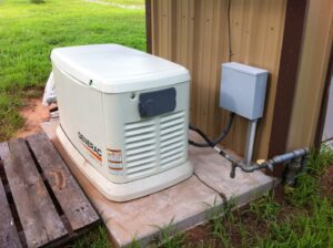 A Generac standby generator installation with electrical and gas connections next to a building by Generator Experts of Oklahoma in Norman, OK.