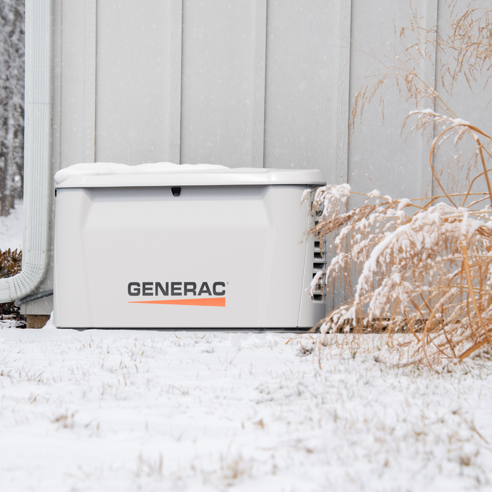 A Generac standby generator installed outside a home in the snow by Kelley Brothers LC in Livonia, MI.