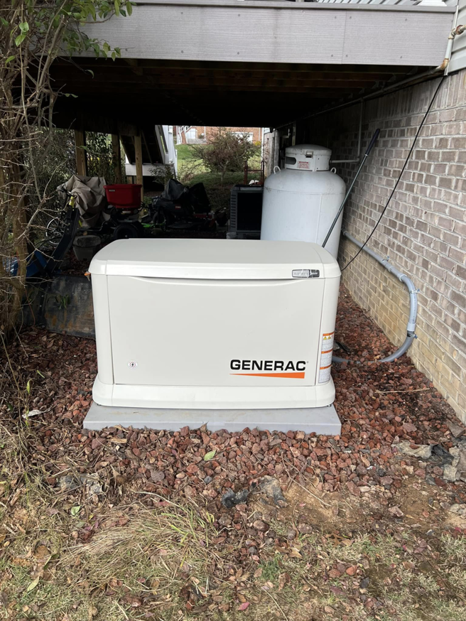 A Generac standby generator installed under a deck next to a propane tank by RJ Boyd Electric in Christiansburg, VA.