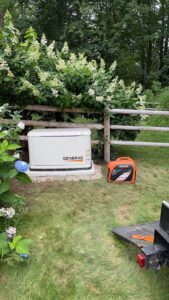 A Generac standby generator installed next to a portable generator by Josh LaFerriere Electric in Westbrook, ME.