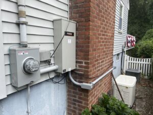 A Generac whole-house generator installation with electrical meter and conduit by Richard Sullivan Licensed Electrician in Brockton, MA.