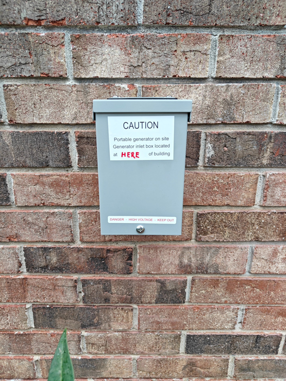 A newly installed generator inlet box on a brick wall by Sherrill Company, LLC Electrical Contractors in Columbus, GA.