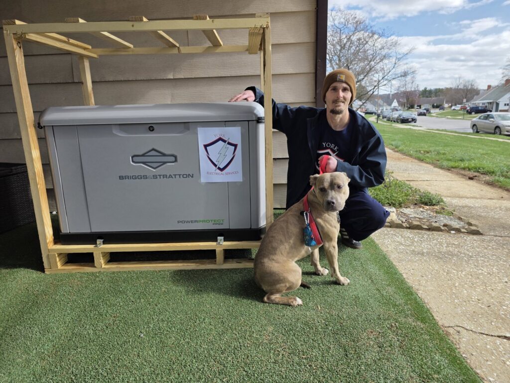 An electrician from York Electrical Services in York, PA, standing next to a newly installed Briggs & Stratton standby generator.