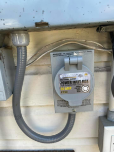 A close-up of a Reliance generator power inlet box installation by Mcgehee Electric, LLC in Montgomery, AL.