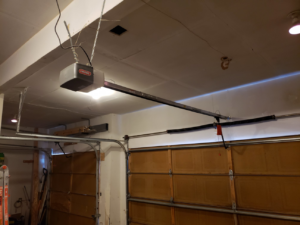 An interior view of a Genie garage door opener, tracks, and torsion springs serviced by 170 Springs LLC Garage Doors in Aurora, CO