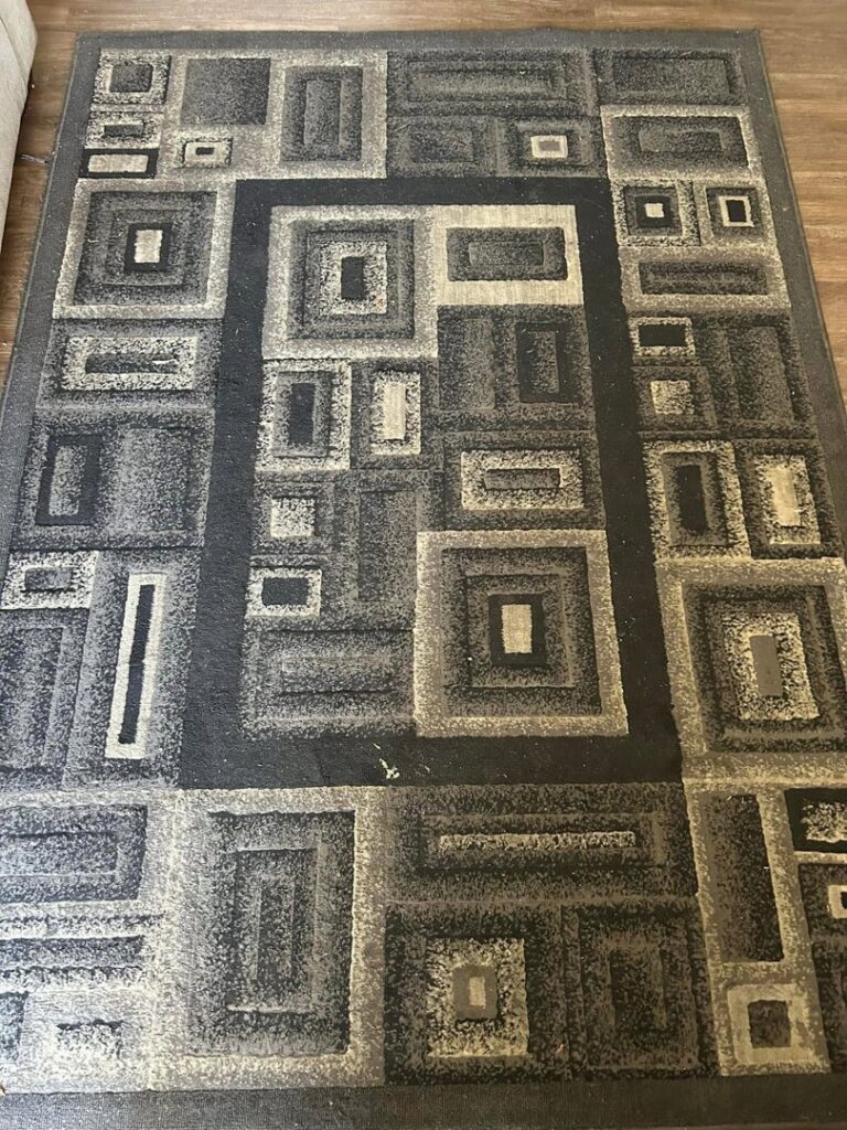 A clean geometric pattern area rug on a wooden floor by Central California King of Clean LLC in Bakersfield, CA.