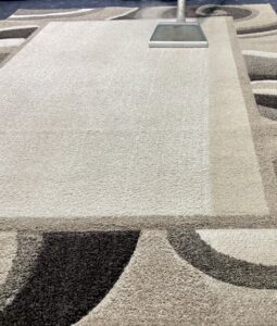 A professional carpet cleaning wand cleaning a large geometric area rug, showing a clean path, by Gemini Carpet Cleaning in Lincoln, NE