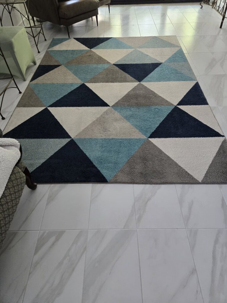 A modern geometric area rug with blue and grey tones, professionally cleaned by Master's Touch Steam Cleaning in San Antonio, TX.