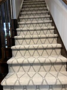 A modern geometric patterned carpet runner professionally installed on a staircase by Garrard's Flooring Service LLC in Cleveland, OH.