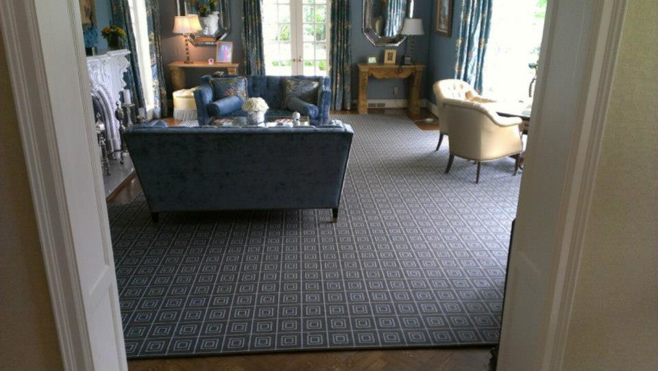 A living room featuring a large geometric pattern carpet installed by Carpet Art of America in O'Fallon, MO.