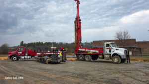 Large geothermal drilling rig trucks and workers at a job site for Jackson Geothermal in Mansfield, OH.