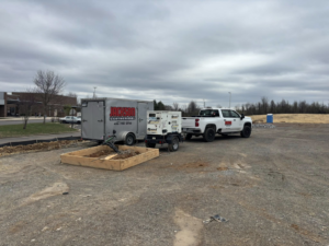 A Jackson Geothermal truck and trailer with equipment at a geothermal installation job site in Mansfield, OH.