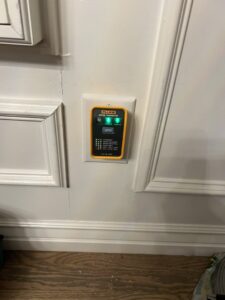 An electrician from Sparrow Electric, LLC testing a GFCI outlet with a tester in Denver, CO.