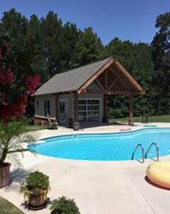 A modern glass garage door installed on a pool house, showcasing work by Summers Garage Door in Denver, CO.