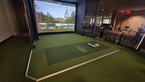 A golf simulator room featuring newly installed green artificial turf by At Home Flooring in Naperville, IL.