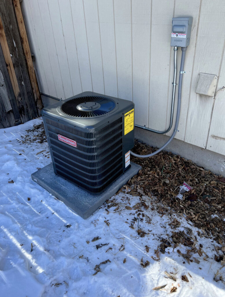 An outdoor Goodman air conditioning unit installed next to a home by Jump HVAC in Lakewood, CO.