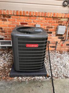 A Goodman outdoor air conditioning unit installed next to a brick wall by Detroit Metro Mechanical, Inc. in Harrison Township, MI.