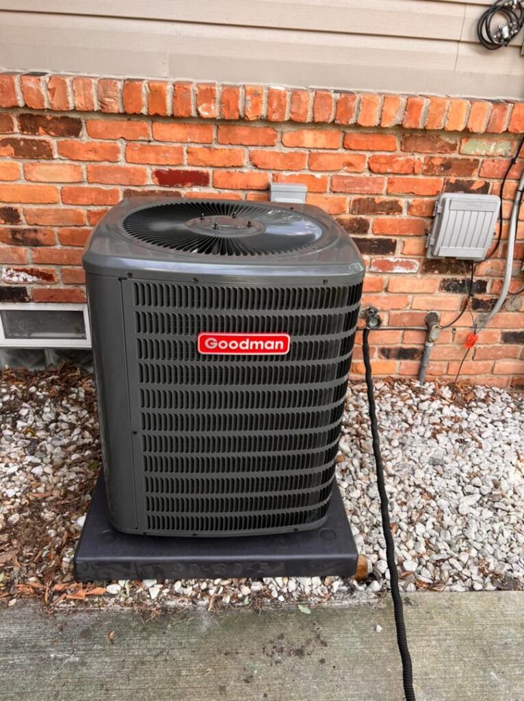 A Goodman outdoor air conditioning unit installed next to a brick wall by Detroit Metro Mechanical, Inc. in Harrison Township, MI.