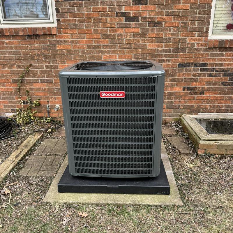 A Goodman outdoor AC unit installed on a concrete pad at a residential property by Hodges Heating & Cooling in Owensboro, KY.